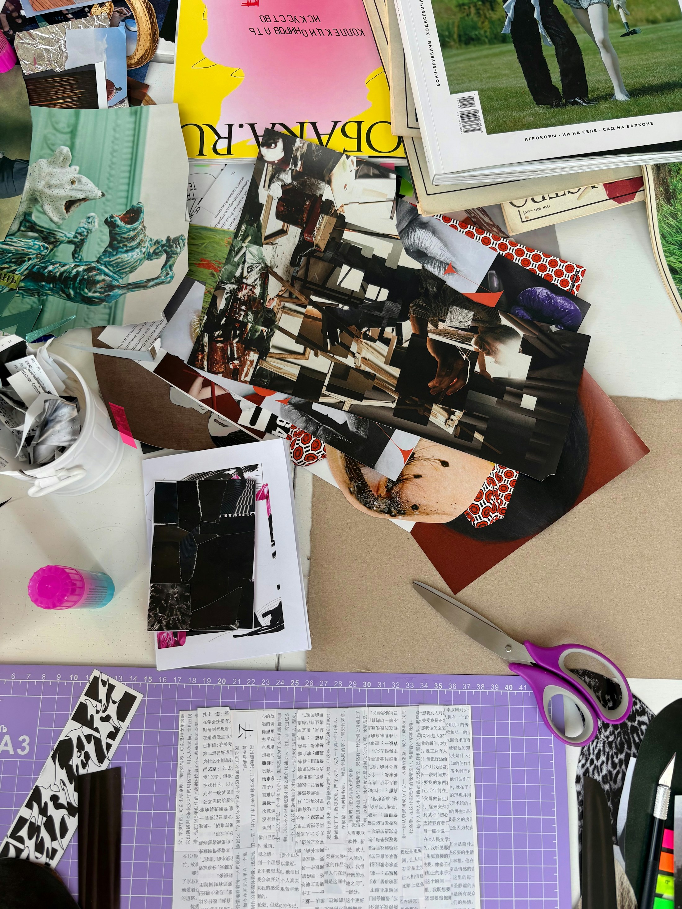 Desk covered with notes, clippings, and creative planning materials